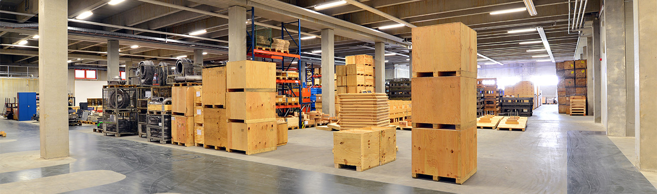 Warenlager mit gestapelten Kartons und Verpackungsmaterial f&uuml;r professionelle Industrieverpackung in Frankfurt und den sicheren Versand von Industrieprodukten.