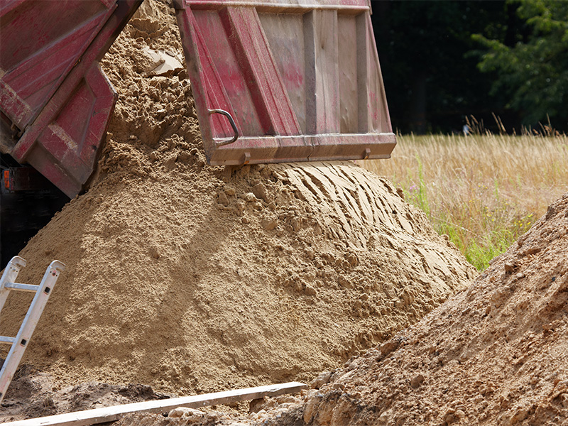 LKW lädt Schüttgüter wie Sand auf Baustelle in Frankfurt für Bau- und Infrastrukturarbeiten im Außenbereich