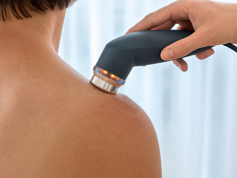 Arzt in Frankfurt behandelt Schulter mit Ultraschallgerät zur gezielten Schmerzlinderung und Förderung der Heilung von Muskel- und Gelenkbeschwerden